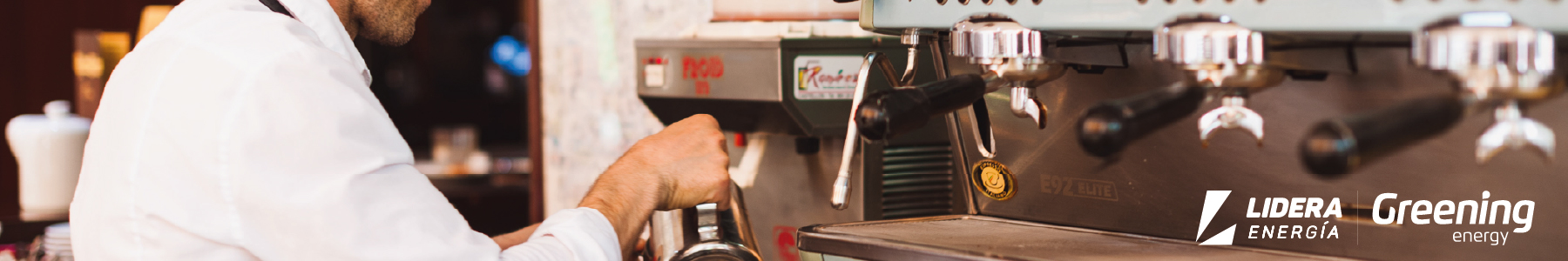 Empleado preparando café en una cafetería equipada con sistemas eléctricos eficientes, representando el ahorro energético en pymes con baterías solares.